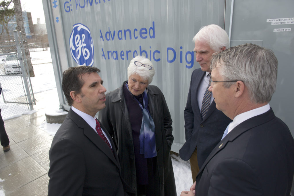 Glenn Vicevic (GE Water & Process Technologies) (Member of Provincial Parliament, Guelph), John Livernois (University of Guelph) & Lloyd Longfield (Member of Parliament, Guelph) standing in front of GE's trailer being used for the project at the SOWC Guelph Wastewater Pilot Facility. Copyright: SOWC